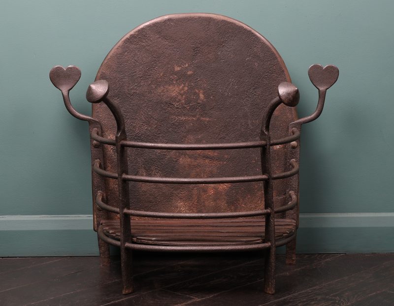 An Arts & Crafts Semi-Circular Wrought Fire Basket with Heart-Shaped finials